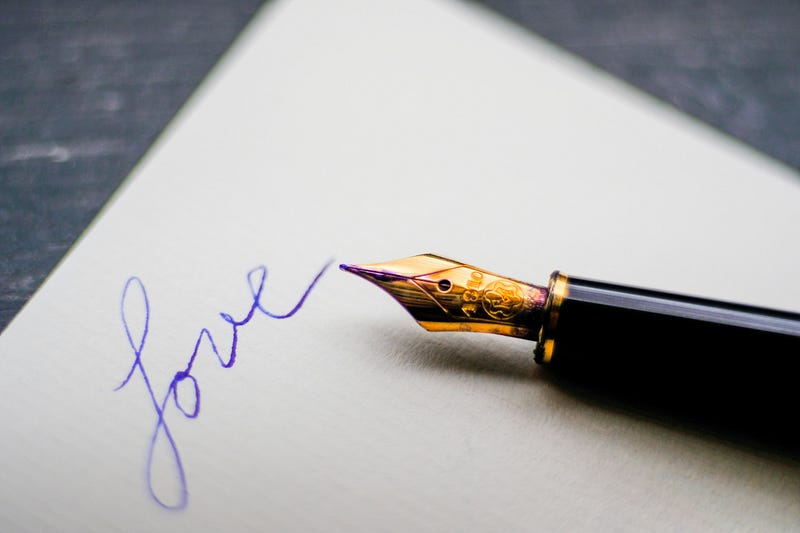 18: picture of a fountain pen on a piece of paper with "Love" written on it
