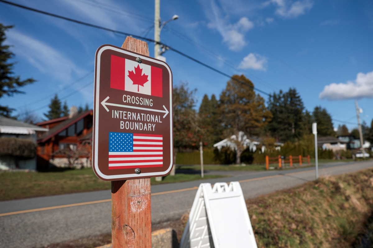 Border: a sign showing the Canada-US border at an undisclosed location