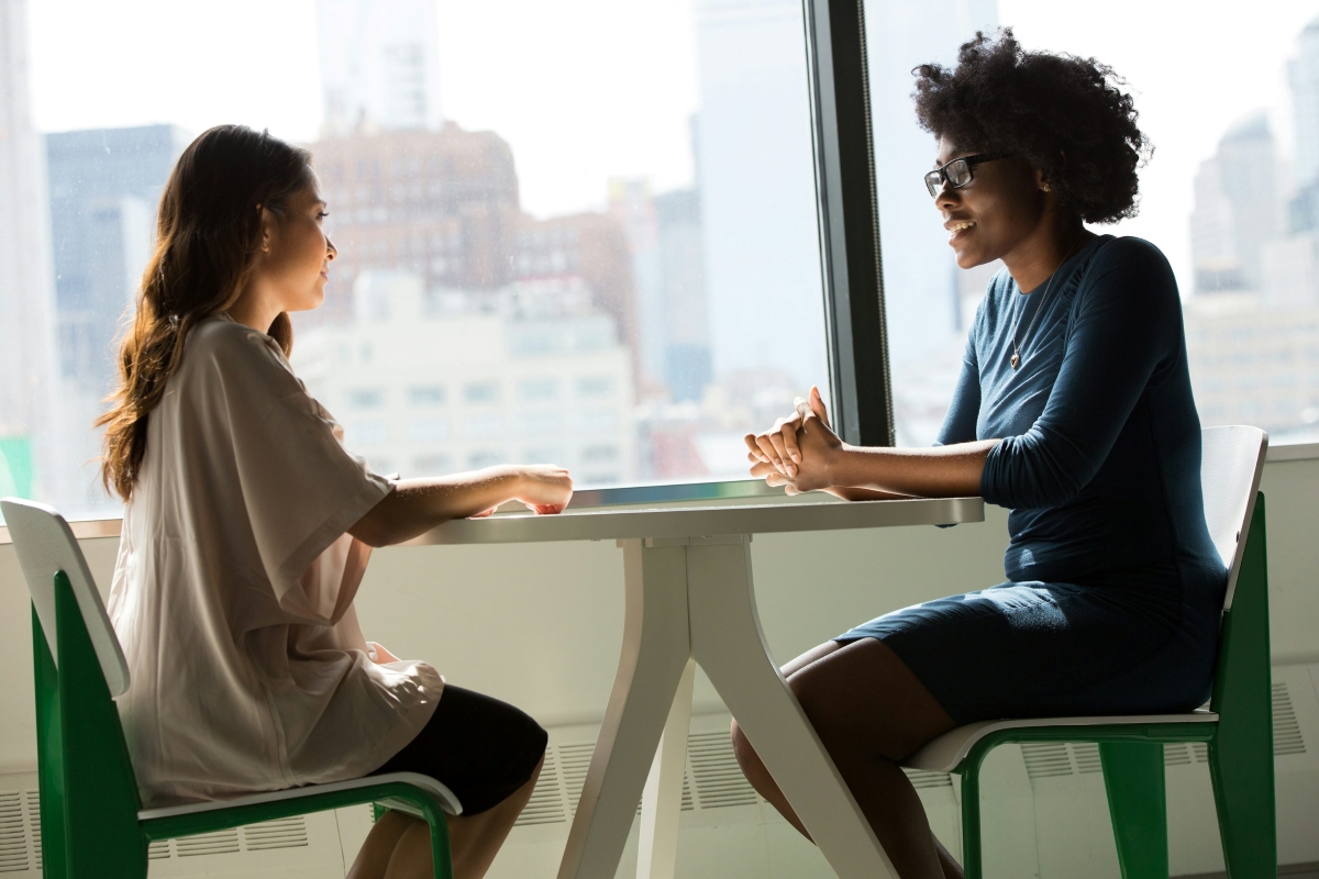 Conversation: 2 women sitting across from each other at a table