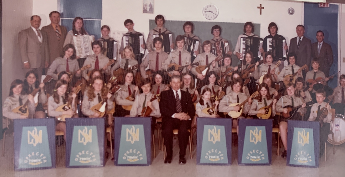 Group photo of an orchestra, with the musical director in the centre