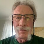 man with a moustache wearing glasses